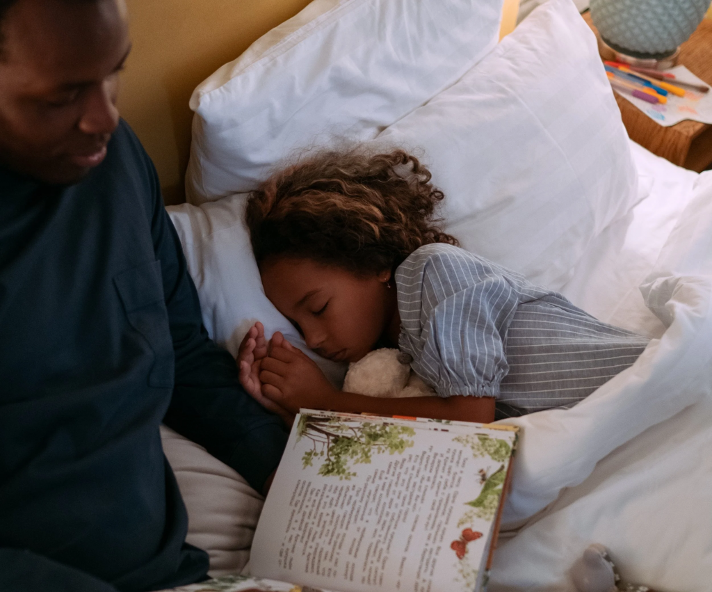 parent reading aloud to young child at bedtime