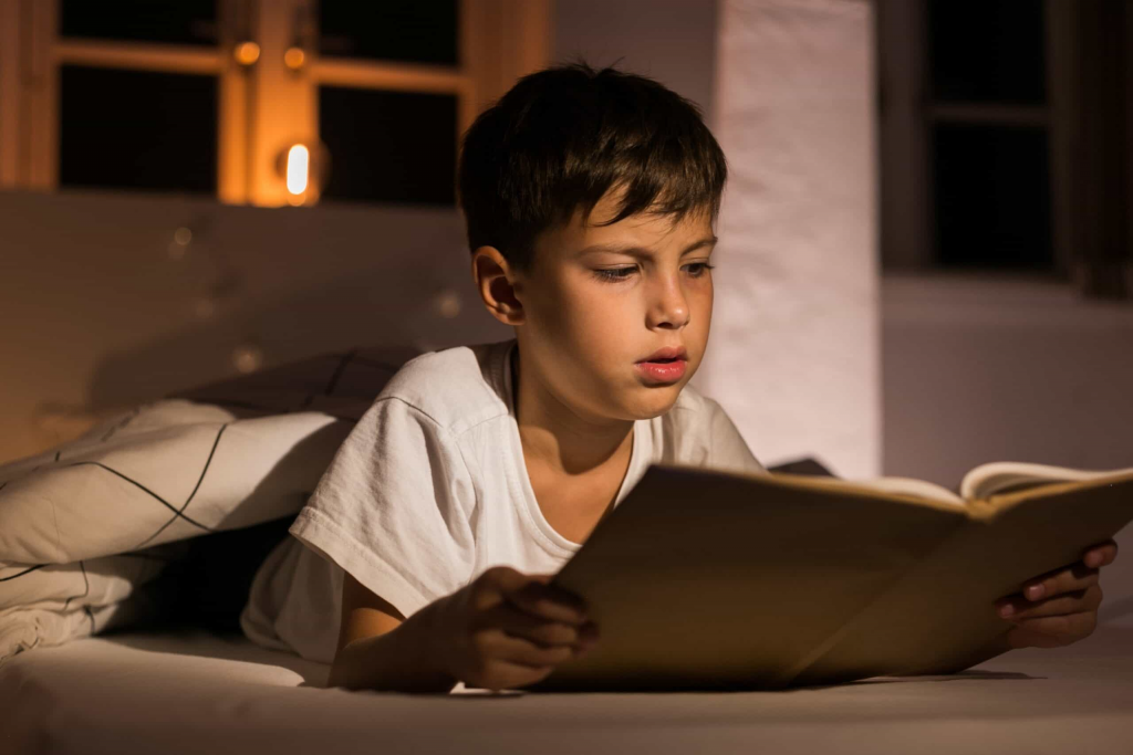 child reading chapter book independently at home ages 7 to 9 reading milestone