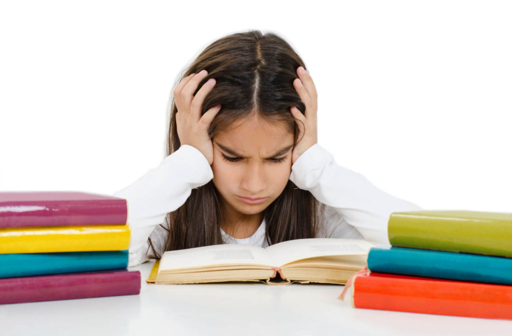 frustrated child struggling with reading comprehension problems at desk