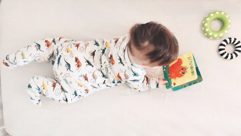 baby looking at board book early reading milestones birth to 12 months