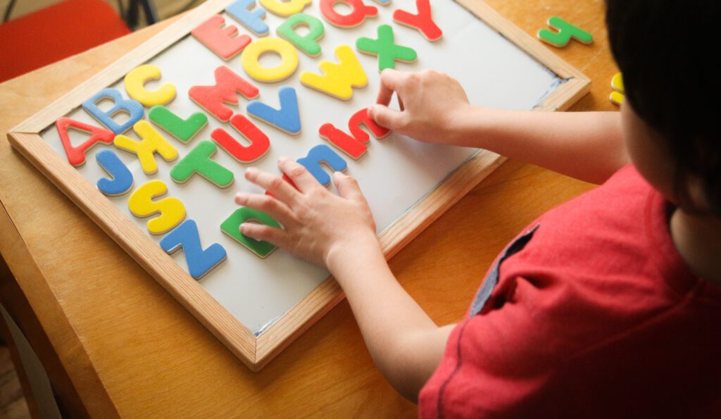 child practicing phonics with colorful alphabet letters and early reading tools
