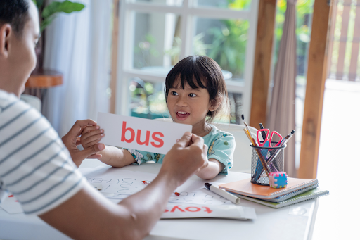 young child holding sight word flashcards learning to read at home