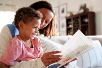 child reading aloud from book to improve reading fluency at home