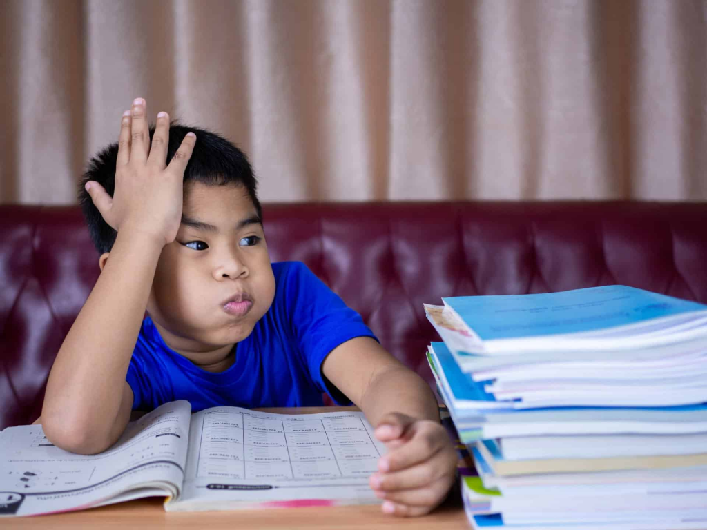 child struggling with reading fluency problem looking frustrated at book