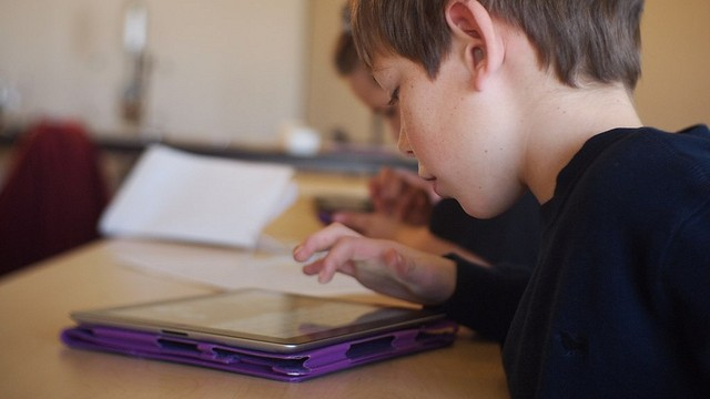 child recording themselves reading on tablet for reading fluency playback activity