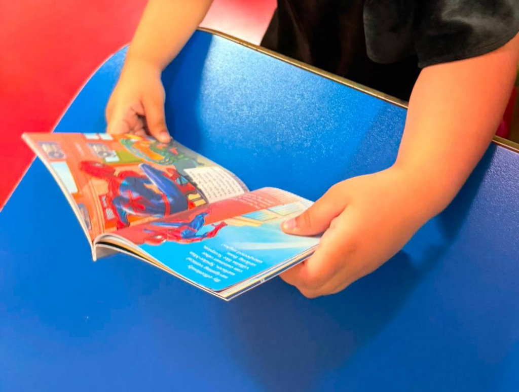 child reading a Spider-Man picture book