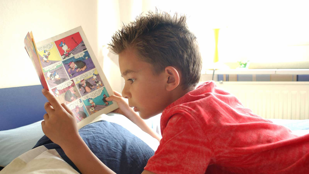 Child reading a graphic novel as part of reading for kids