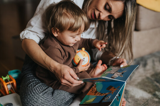 Parent and child reading a book together at home