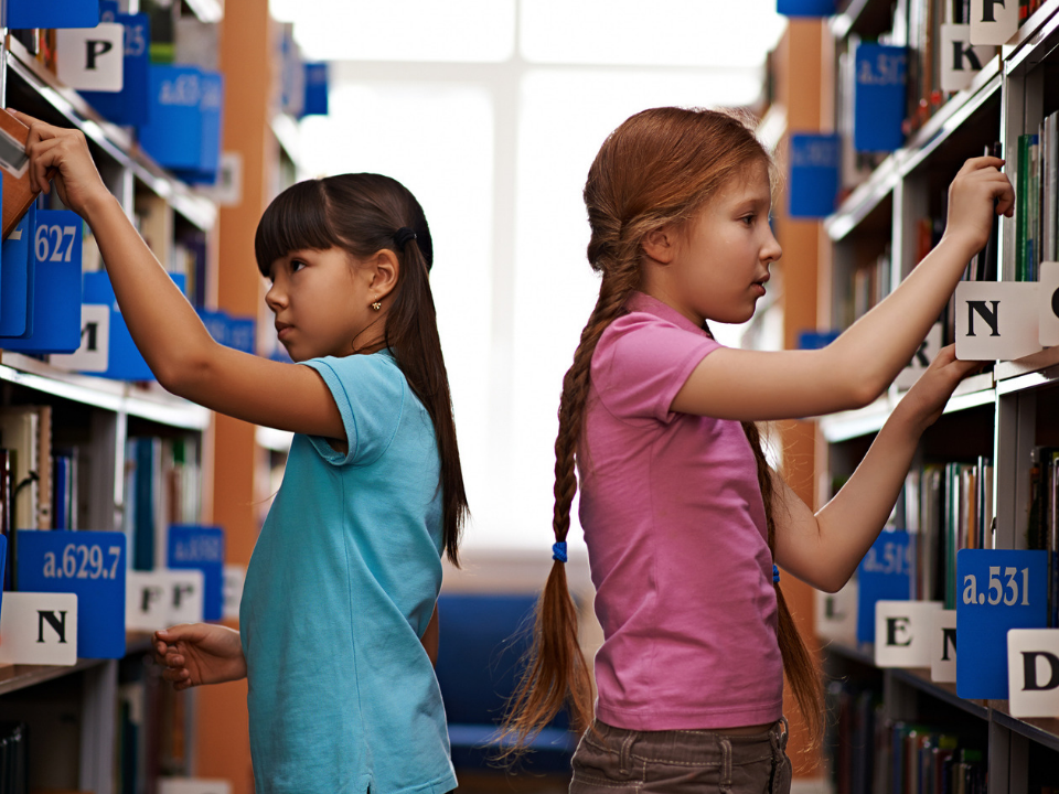 Child choosing books at the right reading level from a bookshelf