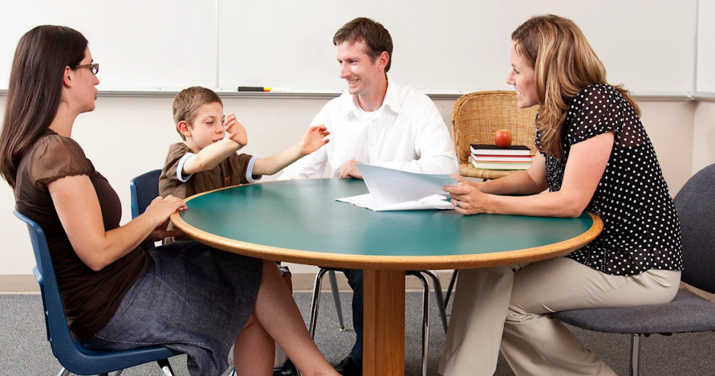 Parent discussing child's reading progress with elementary school teacher