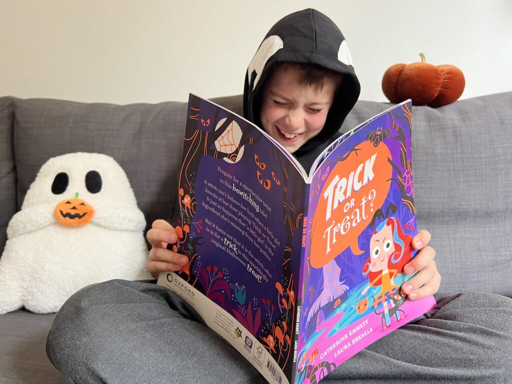 Child reading a Halloween picture book at home