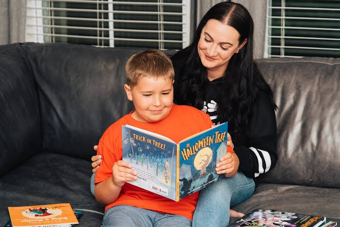 Parent and child reading a Halloween book together