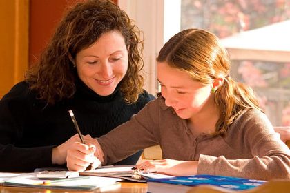 Parent helping child with reading assignments at home