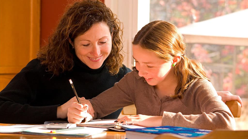 Parent helping child with reading assignments at home