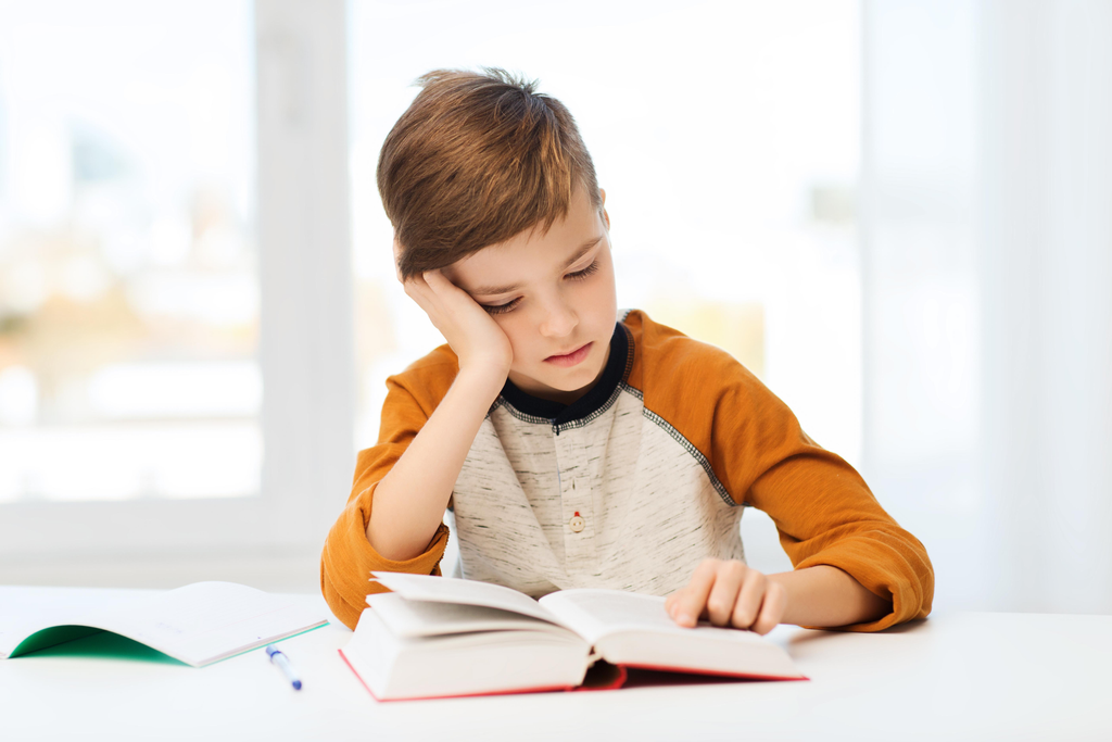 Child looking back at a book to find an answer