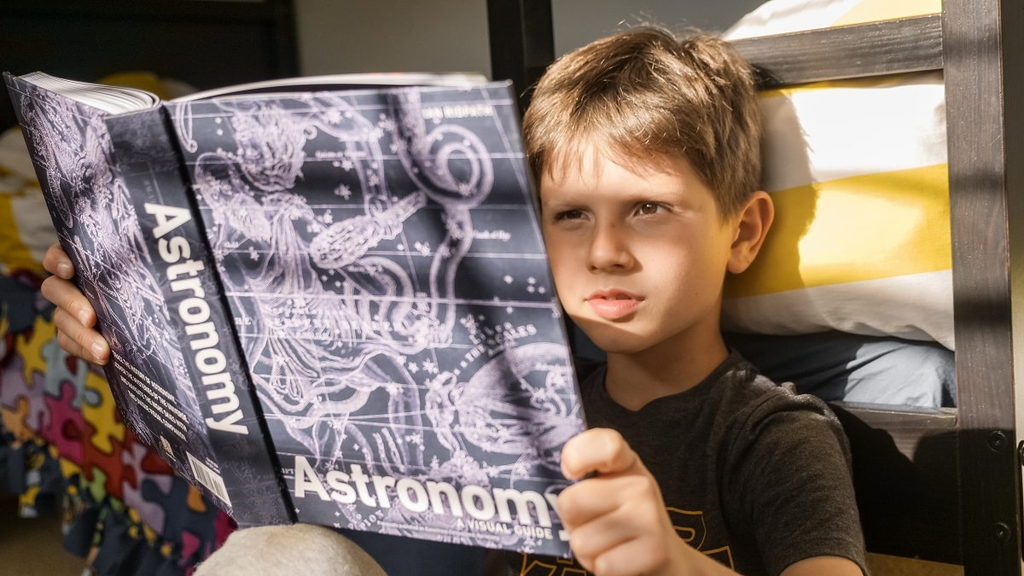Young child exploring a book about space