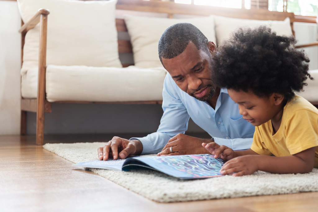 Parent and child looking at the illustrations in a wordless picture book together