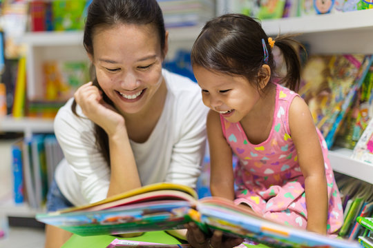 Parent and child discussing illustrations before reading.